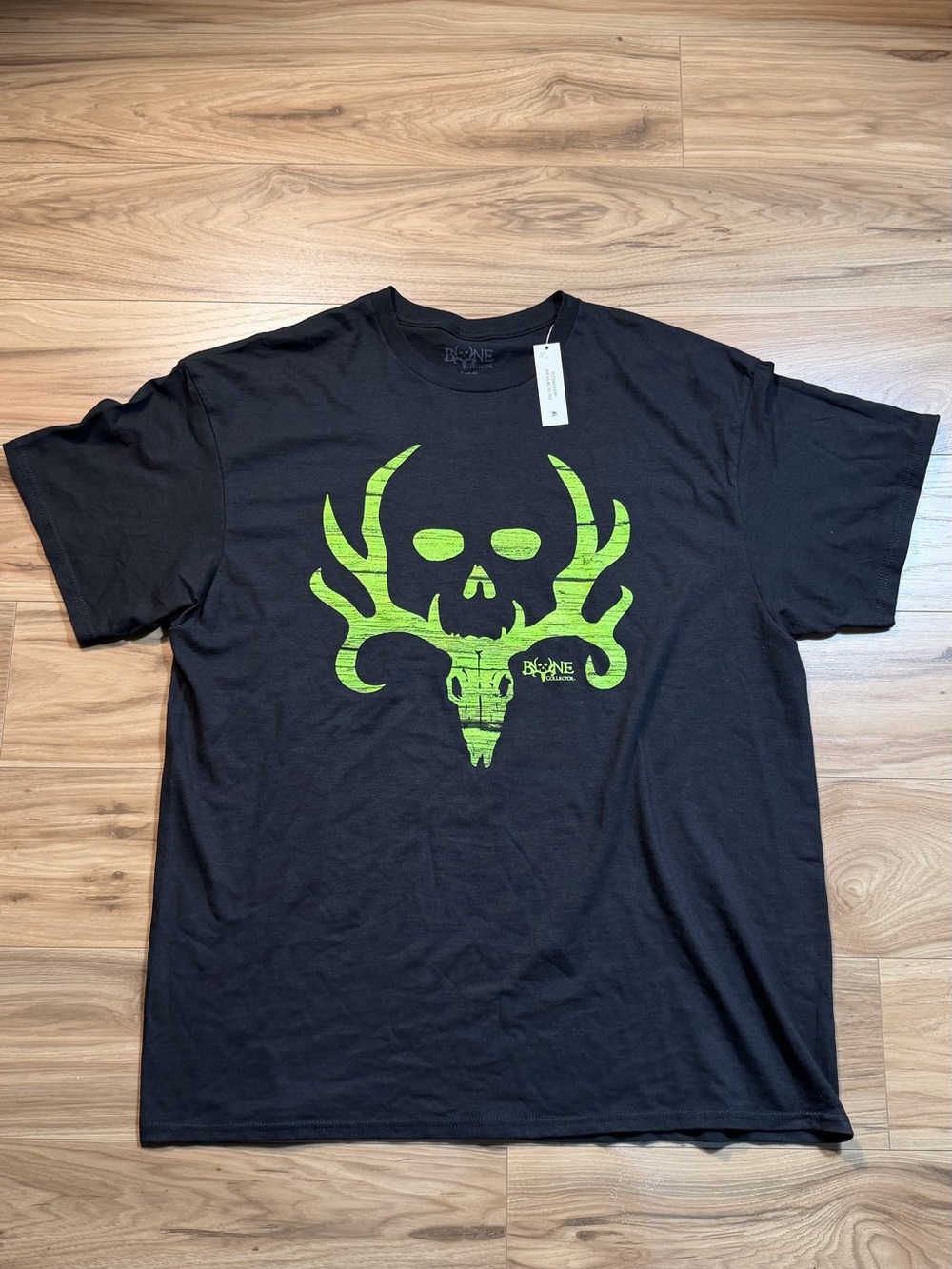 BONE COLLECTOR TEE
Black cotton t-shirt with green skull with antlers graphic